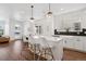 Open concept kitchen with white cabinets, a spacious island, and a view into the dining area at 12270 W 57Th Ave, Arvada, CO 80002