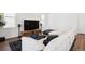 Bright living room features a plush white sectional sofa, large-screen TV, and hardwood floors at 12270 W 57Th Ave, Arvada, CO 80002