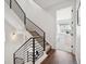 Staircase featuring black metal railing and wood flooring leading to an open bedroom at 12270 W 57Th Ave, Arvada, CO 80002