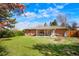 Expansive backyard with lush green grass, patio seating, a fire pit, and a charming brick exterior, ideal for outdoor enjoyment at 8276 E Easter Pl, Centennial, CO 80112
