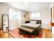 Bright and airy bedroom featuring hardwood floors, large windows with natural light, and a decorative rug at 8276 E Easter Pl, Centennial, CO 80112