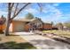 Angle view of brick home featuring an attached garage, concrete driveway and well-manicured lawn at 8276 E Easter Pl, Centennial, CO 80112