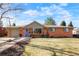 Charming brick home featuring a blue door, well-maintained lawn and attached garage on a beautiful day at 8276 E Easter Pl, Centennial, CO 80112