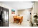 Bright kitchen with wood table set, stainless steel refrigerator, white cabinets, and tile flooring at 8276 E Easter Pl, Centennial, CO 80112