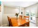 Open kitchen and dining area with a wood table and chairs, leading to a bright outdoor view through glass doors at 8276 E Easter Pl, Centennial, CO 80112