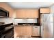 Modern kitchen with stainless steel appliances and wood cabinets at 2837 Vallejo St # 108, Denver, CO 80211