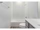 Bright white bathroom features tiled wall, combination tub and shower, and grey vanity at 5783 N Jericho Way, Aurora, CO 80019