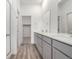 Bright bathroom with double vanity, quartz countertops, leading to walk-in closet at 5783 N Jericho Way, Aurora, CO 80019