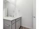 Bright half bathroom features vanity with mirror, sink, and grey cabinets at 5783 N Jericho Way, Aurora, CO 80019
