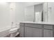Bright, white bathroom features grey vanity, mirror, and combination tub and shower at 5783 N Jericho Way, Aurora, CO 80019