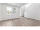 Open-concept living room with wood-style floors, natural light, and staircase access at 5783 N Jericho Way, Aurora, CO 80019
