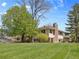 Backyard view of charming home with lush green lawn and mature trees at 6490 S Pontiac Ct, Centennial, CO 80111