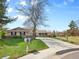 Lovely home with a long driveway, mature trees, and a well-maintained lawn on a sunny day at 6490 S Pontiac Ct, Centennial, CO 80111
