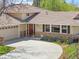 Beautiful home showcasing colorful flowerbeds, a stone facade, and a spacious driveway at 6490 S Pontiac Ct, Centennial, CO 80111