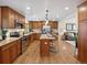 Open kitchen boasts an island, granite countertops, wood cabinets, and stainless steel appliances at 6490 S Pontiac Ct, Centennial, CO 80111