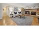 Comfortable living room with hardwood floors, brick fireplace, and neutral-colored sofa with accent pillows at 6490 S Pontiac Ct, Centennial, CO 80111