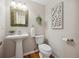 The powder room features a pedestal sink, decorative mirror and nice wall decorations at 6490 S Pontiac Ct, Centennial, CO 80111