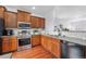 Modern kitchen with stainless steel appliances and wood cabinets at 1143 Autumn Star Pt, Monument, CO 80132