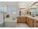 Bright bathroom featuring a soaking tub, separate shower, and dual vanities with tile countertops at 12957 W 78Th Cir, Arvada, CO 80005