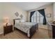 Comfortable bedroom with dark wood furniture, neutral walls, and a window with dark curtains at 12957 W 78Th Cir, Arvada, CO 80005