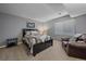 Cozy bedroom with a black wood bed frame, neutral walls, and a leather armchair at 12957 W 78Th Cir, Arvada, CO 80005