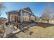 Back exterior view of home featuring a patio with seating, grill, and well-manicured lawn at 12957 W 78Th Cir, Arvada, CO 80005