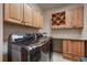 Functional laundry room equipped with modern washer and dryer, storage cabinets, and counter space at 12957 W 78Th Cir, Arvada, CO 80005