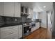 Modern kitchen featuring stainless steel appliances, a stylish black backsplash, and sleek countertops at 716 S Osage St, Denver, CO 80223