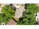 Aerial view of a home with a large roof, mature trees, and a beautifully landscaped yard at 7742 W Florida Dr, Lakewood, CO 80232