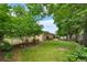 A lush backyard with mature trees, green lawn, garden beds, and fenced perimeter at 7742 W Florida Dr, Lakewood, CO 80232