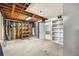 Spacious unfinished basement with exposed ceiling, shelving and utility installations offering customization potential at 7742 W Florida Dr, Lakewood, CO 80232
