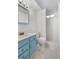 Bathroom featuring blue vanity with marble countertop, toilet and shower stall with tiled walls at 7742 W Florida Dr, Lakewood, CO 80232