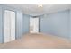 Bedroom with light blue walls, neutral carpeting, closet with paneled doors and an interior door at 7742 W Florida Dr, Lakewood, CO 80232