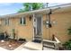A brick home exterior with a covered entry, small garden, and sidewalk at 7742 W Florida Dr, Lakewood, CO 80232