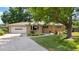 Charming single-story home with a well-manicured lawn, lush landscaping, and an attached two-car garage at 7742 W Florida Dr, Lakewood, CO 80232