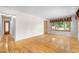 Bright living room featuring hardwood floors, a large window with decorative curtains, and neutral wall colors at 7742 W Florida Dr, Lakewood, CO 80232