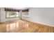 Bright living room featuring hardwood floors and two bright windows with decorative curtains at 7742 W Florida Dr, Lakewood, CO 80232