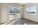 Sun-filled dining area with hardwood floors, a modern chandelier, and large windows overlooking the backyard at 16840 Mckay Dr, Mead, CO 80542