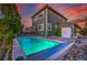 An evening view of the backyard pool showcases ambient lighting and an attached deck for outdoor enjoyment at 2587 S Flanders Ct, Aurora, CO 80013