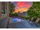 A glowing sunset illuminates the backyard pool and deck area, equipped with lounge chairs for relaxation at 2587 S Flanders Ct, Aurora, CO 80013