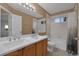Bathroom with a double sink vanity, large mirror, and a shower-tub combination at 2587 S Flanders Ct, Aurora, CO 80013
