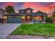 Charming two-story home with manicured lawn and a two-car garage, set against a stunning sunset backdrop at 2587 S Flanders Ct, Aurora, CO 80013