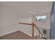 Bright hallway with a wooden banister, chandelier, and view of the neighborhood through the window at 2587 S Flanders Ct, Aurora, CO 80013