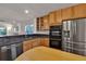 Well-equipped kitchen featuring stainless steel appliances, granite countertops, and modern cabinets, open to living area at 2587 S Flanders Ct, Aurora, CO 80013