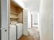 Convenient laundry area with washer and dryer located in hallway closet with shelving for storage at 6376 Lamar Pl, Arvada, CO 80003