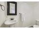 Neat half bathroom with a pedestal sink, dark framed mirror, and neutral colored walls at 3734 Licorice Trl, Castle Rock, CO 80109