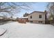 Home's backyard with snow covered lawn and deck at 15895 E 17Th Pl, Aurora, CO 80011