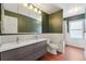 Modern bathroom with double vanity, green walls, and new flooring at 15895 E 17Th Pl, Aurora, CO 80011