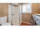 Bathroom with shower stall, toilet, and washer/dryer at 15895 E 17Th Pl, Aurora, CO 80011