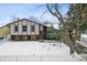 Ranch style home with a fenced yard, snow covered lawn, and mature trees at 15895 E 17Th Pl, Aurora, CO 80011